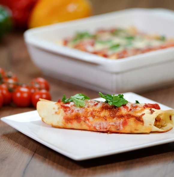 Traditional mexican enchiladas with chicken meat, spicy tomato sauce and cheese on a plate. Mexican cuisine