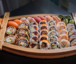 a variety of sushi in a small boat like platter