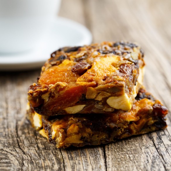 Delicious vegetarian granola cake slice on wooden table.