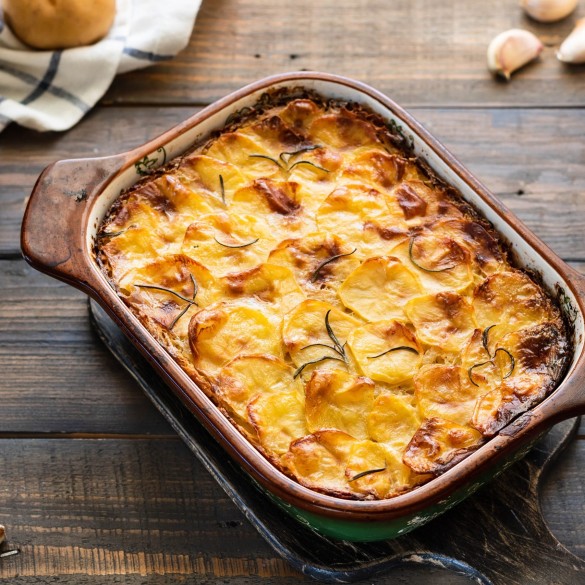 Potato casserole with garlic and rosemary. Simple and tasty food. Village lunch.